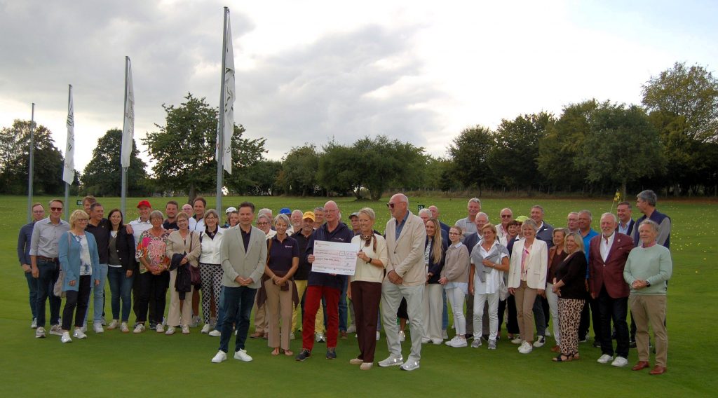 Gruppe auf dem Golfplatz mit Spendenscheck